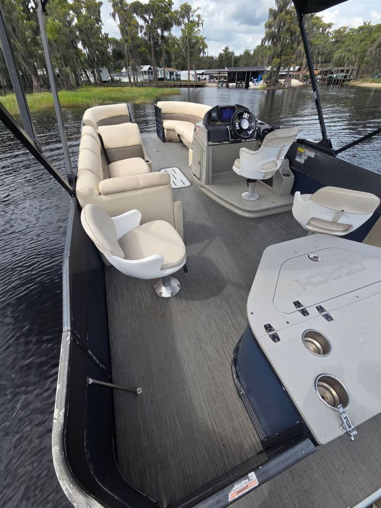 Streak's open deck with swivel chairs, lounge seating and helm on a cypress-lined lake
